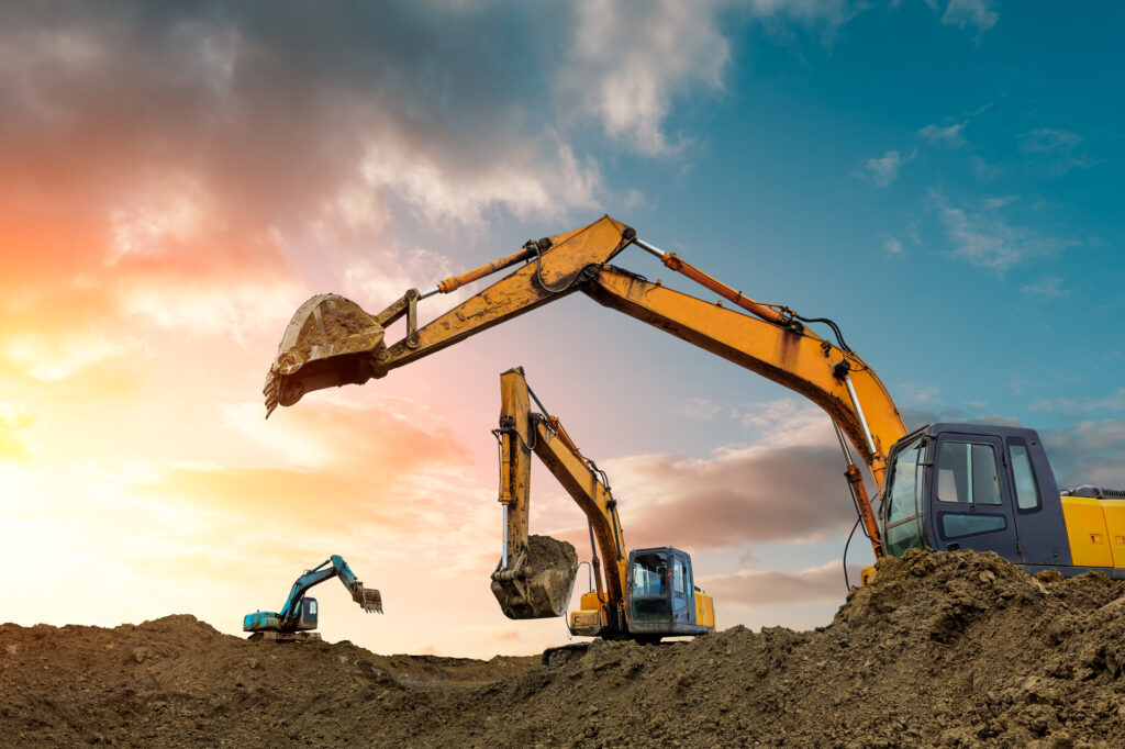 Excavators working on a civil construction project at sunset